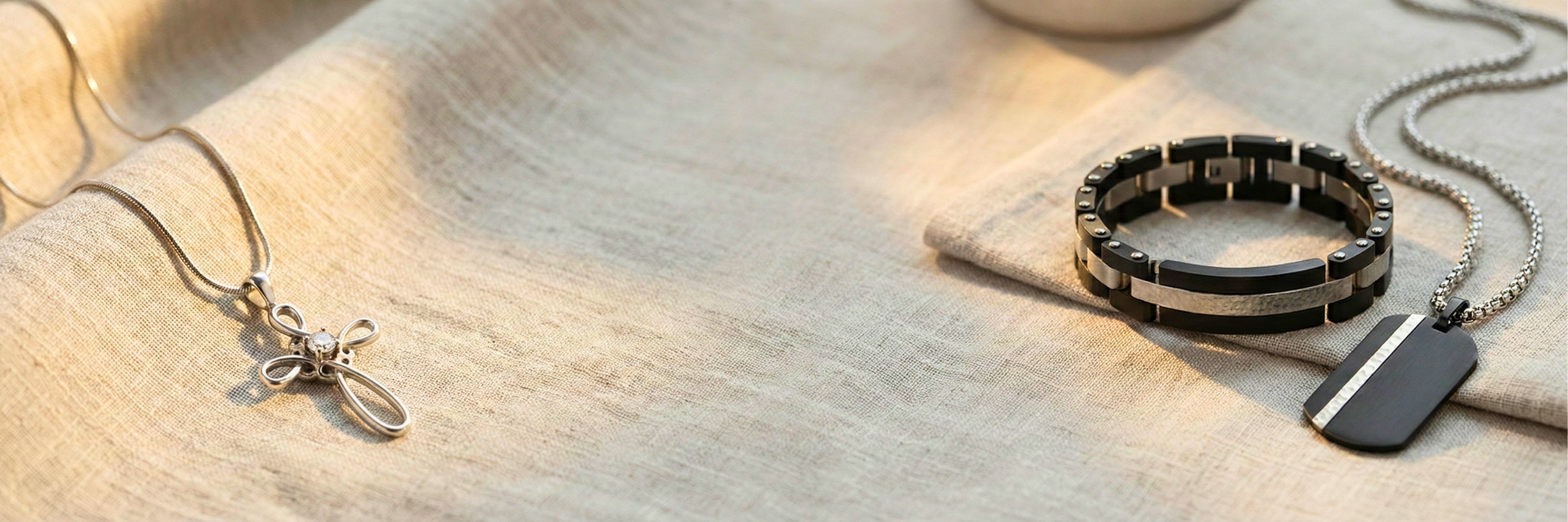 Memorial jewelry collection featuring silver cross pendant, black link bracelet, and dog tag necklace on linen — Magnolia Memorial Marketplace